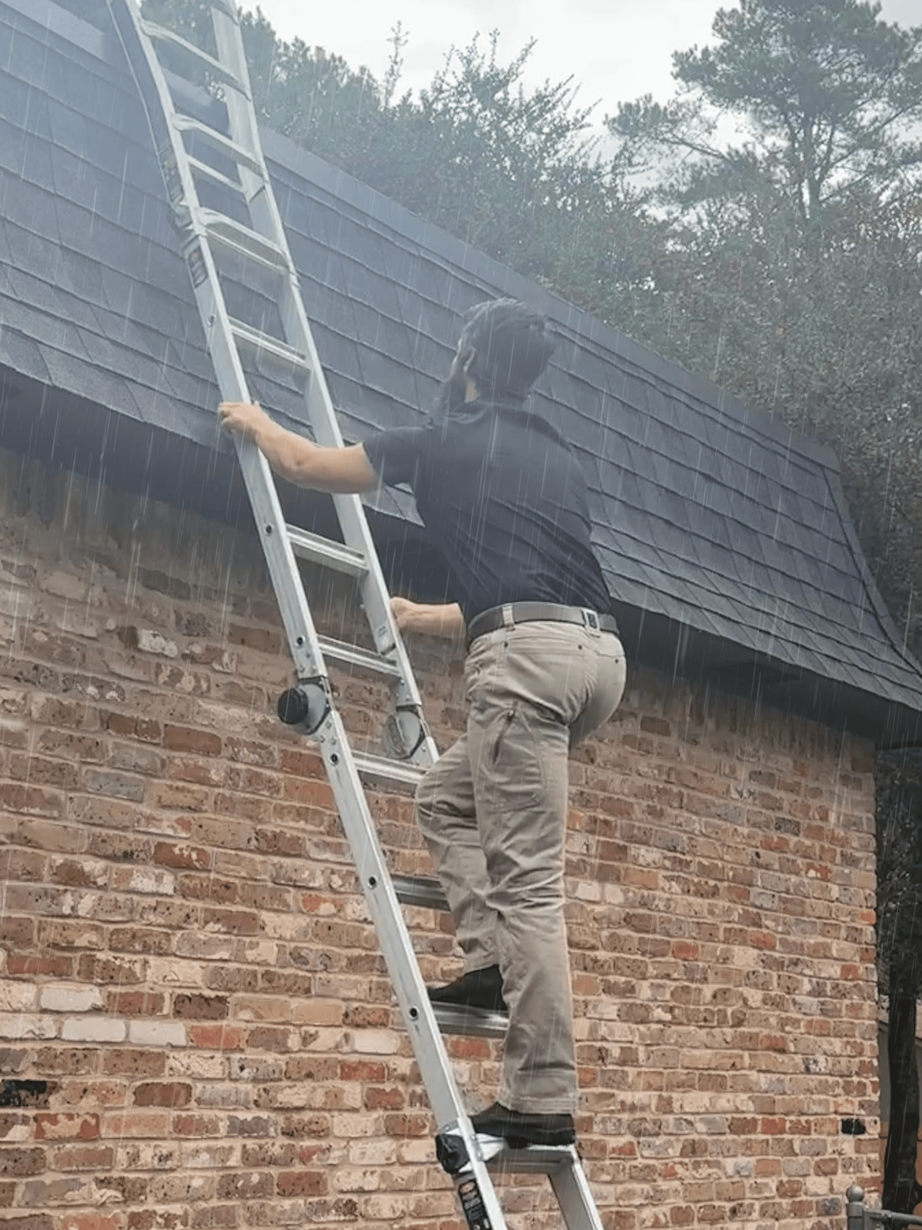 Michael Kubara, a home inspector in Jacksonville, Tyler, and East Texas, climbs a ladder during a rainy day to inspect the roof of a house, showcasing his dedication to thorough home inspections